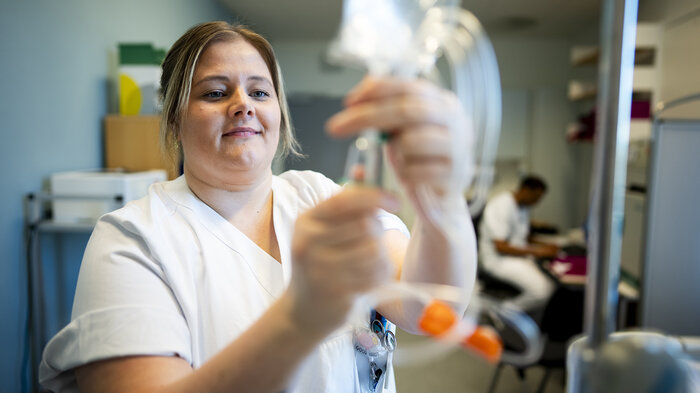 Bilde viser spesialsykepleier Lena Trogstad Risvik som åpner en intravenøspose.