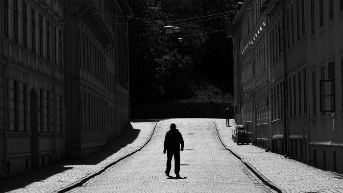 Bildet viser en person bakfra i et bymiljø