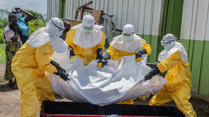 Arbeidere fra Røde Kors flytter på en person som døde av ebola nær helsesenteret i Rwampara i Kongo.
