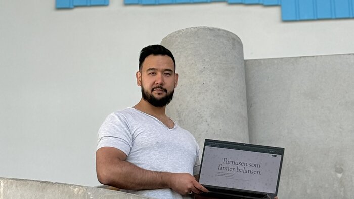 Bildet viser Daniel Norlan som holder frem datamaskinen