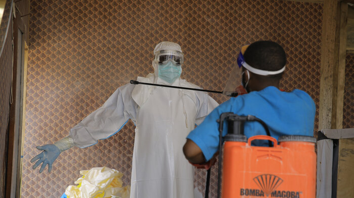 En helsearbeider blir desinfisert av en kollega inne på et behandlingssenter for ebolapasienter i Beni i Nord-Kivu-provinsen, øst i Kongo, tirsdag