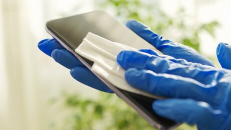 Smittevern Bildet viser en mobiltelefon som blir desinfisert med en klut