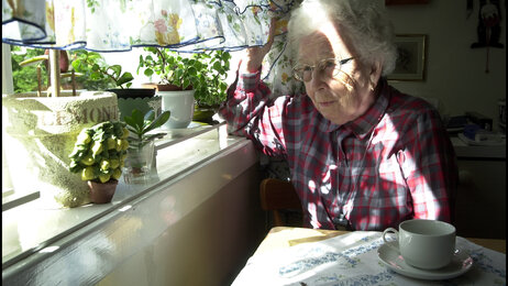 Illustrasjonsfoto: Eldre dame ser ut av vinduet.