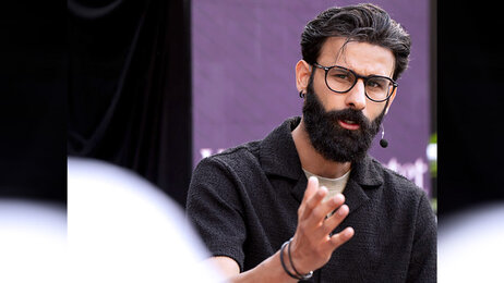 Bildet viser et bilde av artikkelforfatter Farhan Shah som snakker til en forsamling