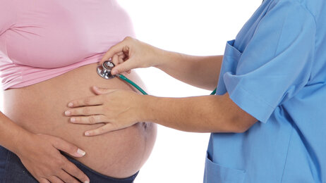En god hjemmebasert barselomsorg er helt avhengig av økte jordmorressurser, skriver leder i Jordmorforbundet NSF. Bildet viser lytting med stetoskop mot høygravid mage.