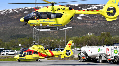 Luftambulanse Bildet viser et ambulansehelikopter som er i ferd med å lette, og et som står på bakken i bakgrunnen