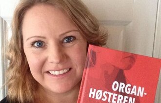 Bildet viser Kristine Lindhøy som holder romanen sin.