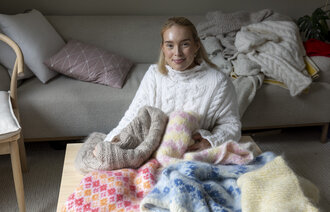 Bildet viser Maria Tessem med flere ulike gensere.