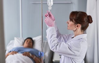Bildet viser en sykepleier som gir medisinsk behandling