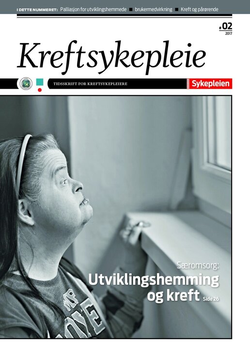 Viser en voksen kvinne med Downs syndrom som titter ut av et vindu Viser en voksen kvinne med Downs syndrom som titter ut av et vindu