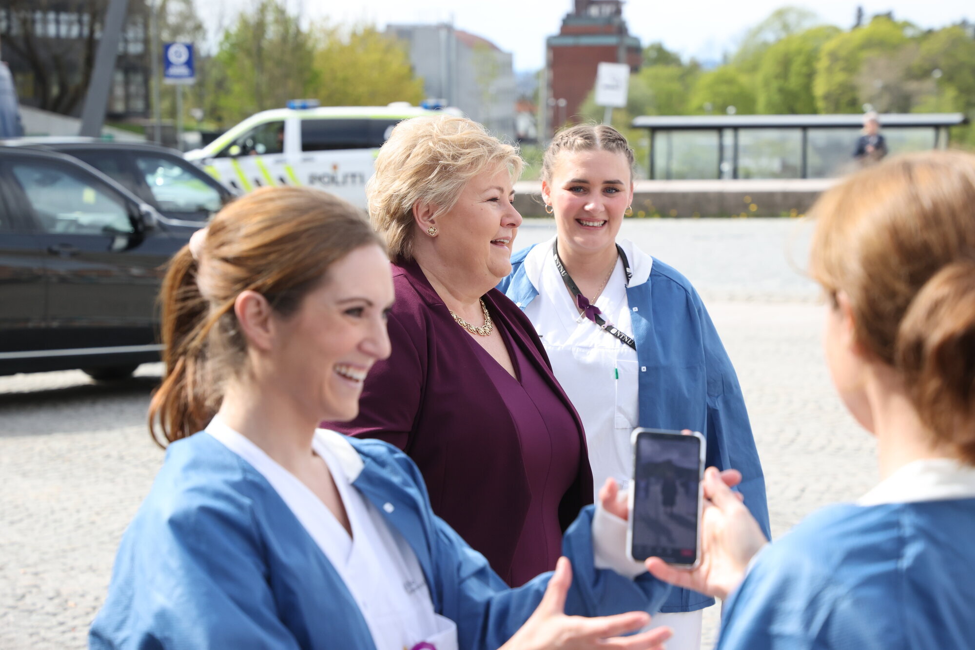 Ida Gerø, Erna Solberg Bildet viser Ida Gerø med mobiltelefon, i bakgrunnen statsminister Erna Solberg og andre sykepleiere.