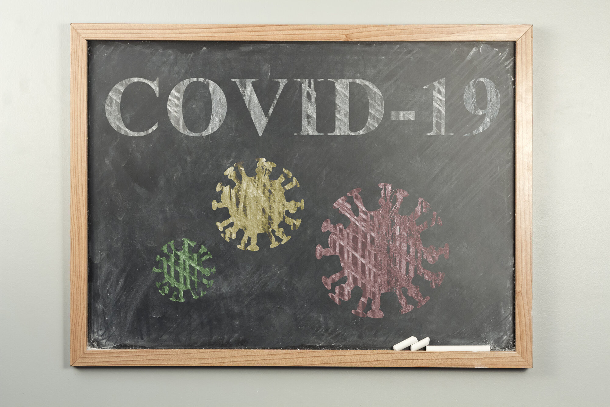 Koronaviruset Bildet viser en skoletavle. På tavlen står det skrevet covid-19 og det er tegninger av koronaviruset.