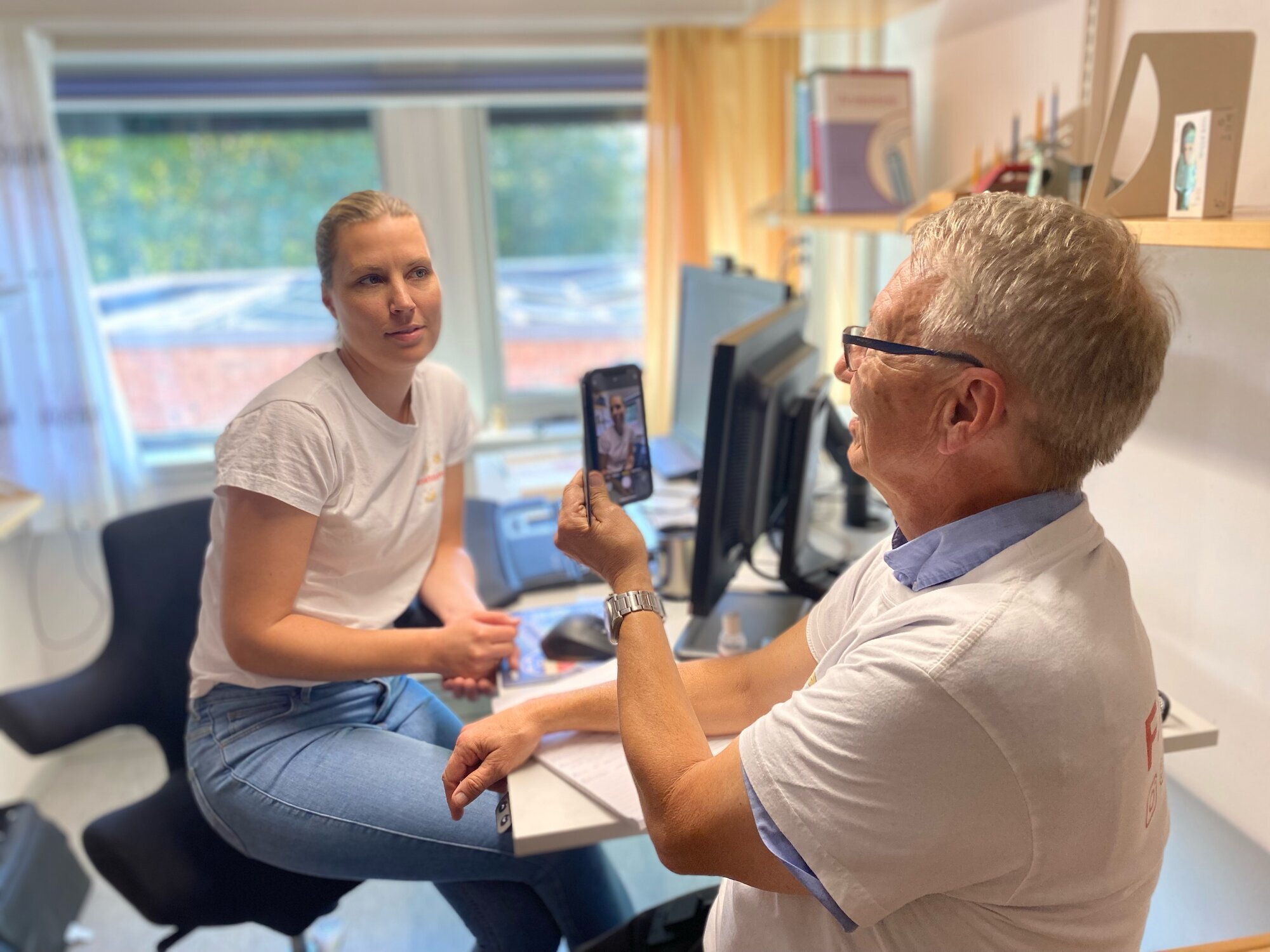 Marianne Sjuls, Jørn Hustad, Universitetet i Agder Bildet viser Jørn Hustad som tar bilde av Marianne Sjuls med mobiltelefon.
