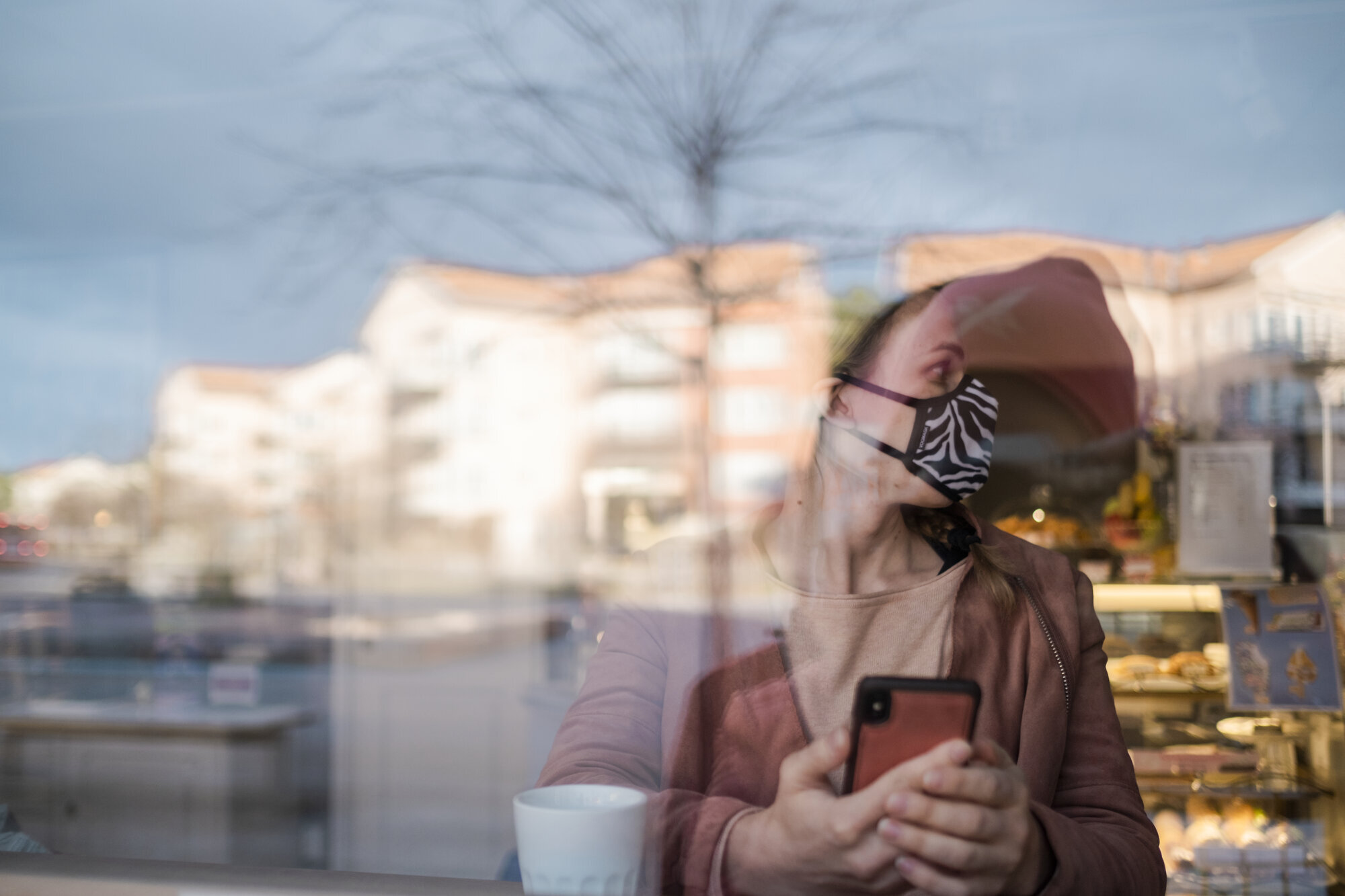Smittetiltak Kvinne med ansiktsmaske bak vindu