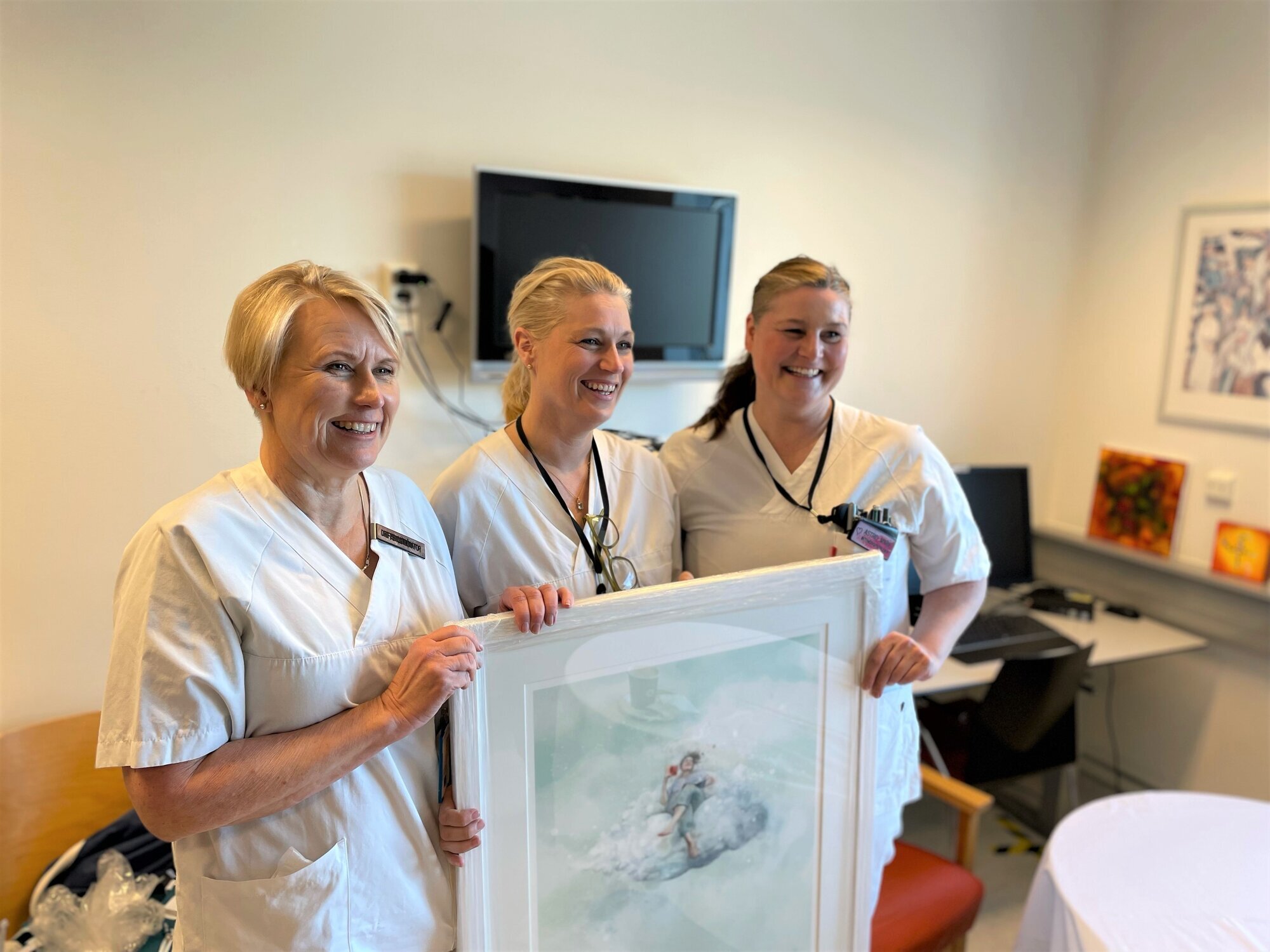 Sylvi Vullum Bildet viser Sylvi Vullum og to kolleger som holder frem et bilde.