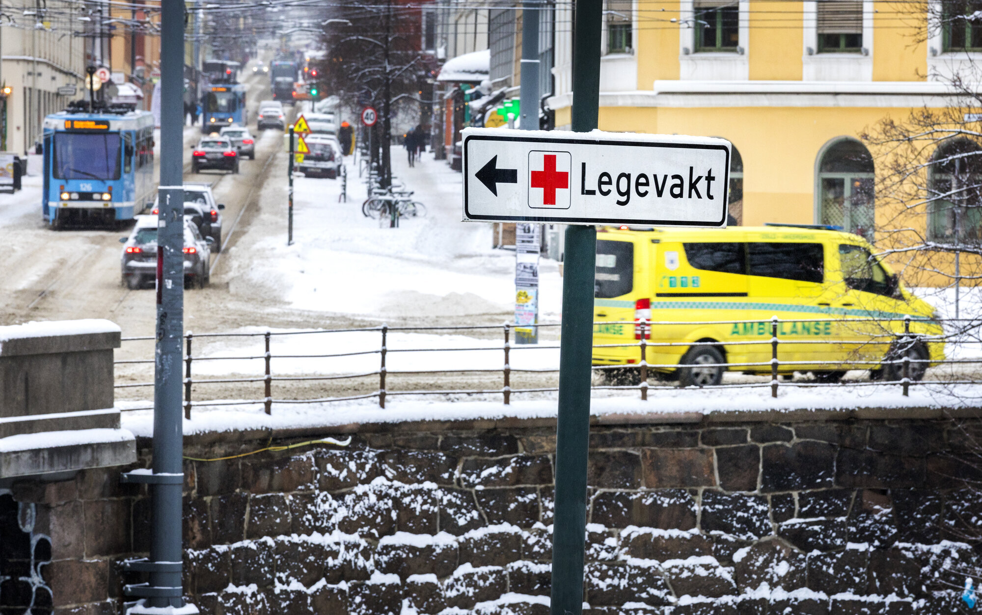 Ambulanse i Oslo Bildet viser trafikkbildet i Oslo. Et skilt peker til Legevakta, mens en ambulanse kjører forbi