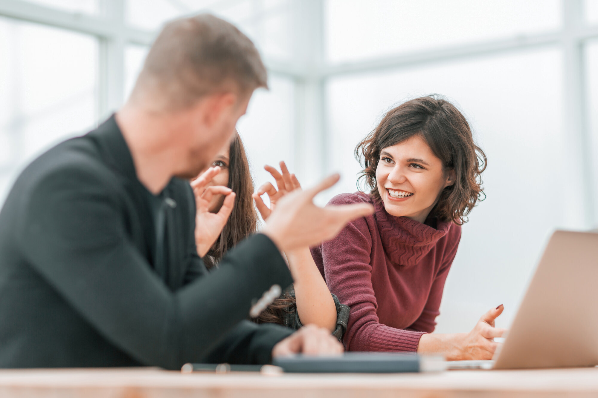 Studenter diskuterer En mannlig og to kvinnelige studenter diskuterer foran en datamaskin.