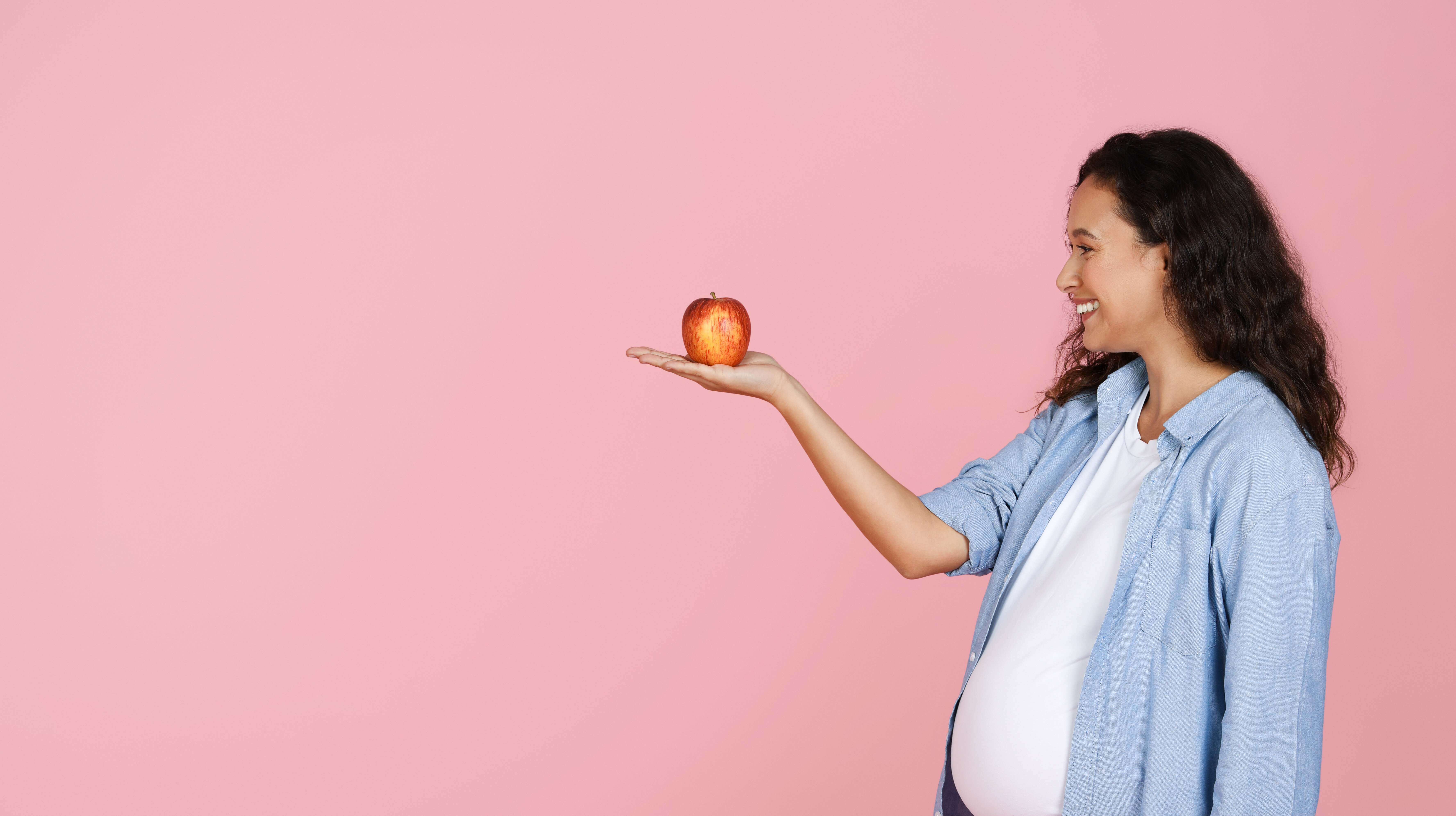Gravid, kvinne, eple Bildet viser en gravid kvinne som holder et eple.
