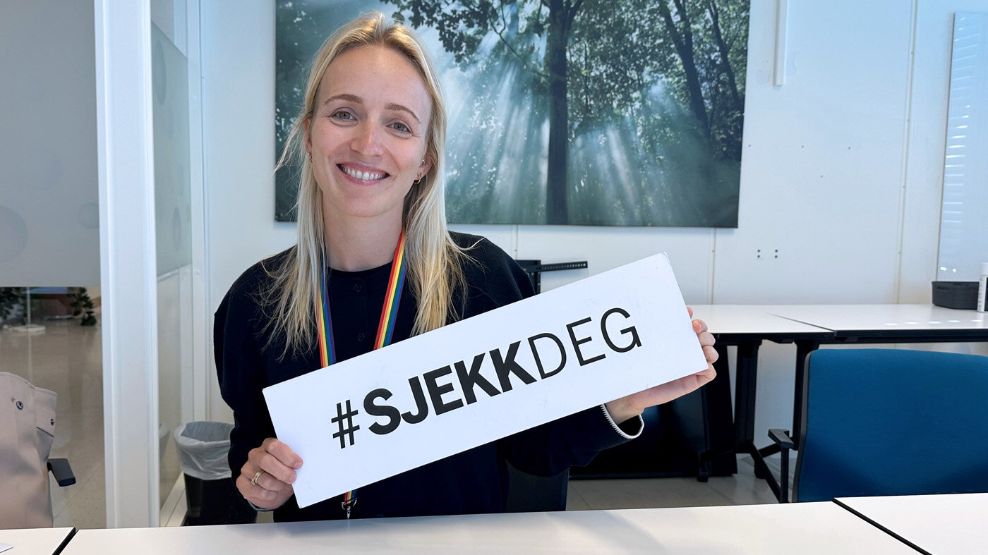 Bilde viser Elin Englund Ørum, med en plakat som sier #sjekkDEG