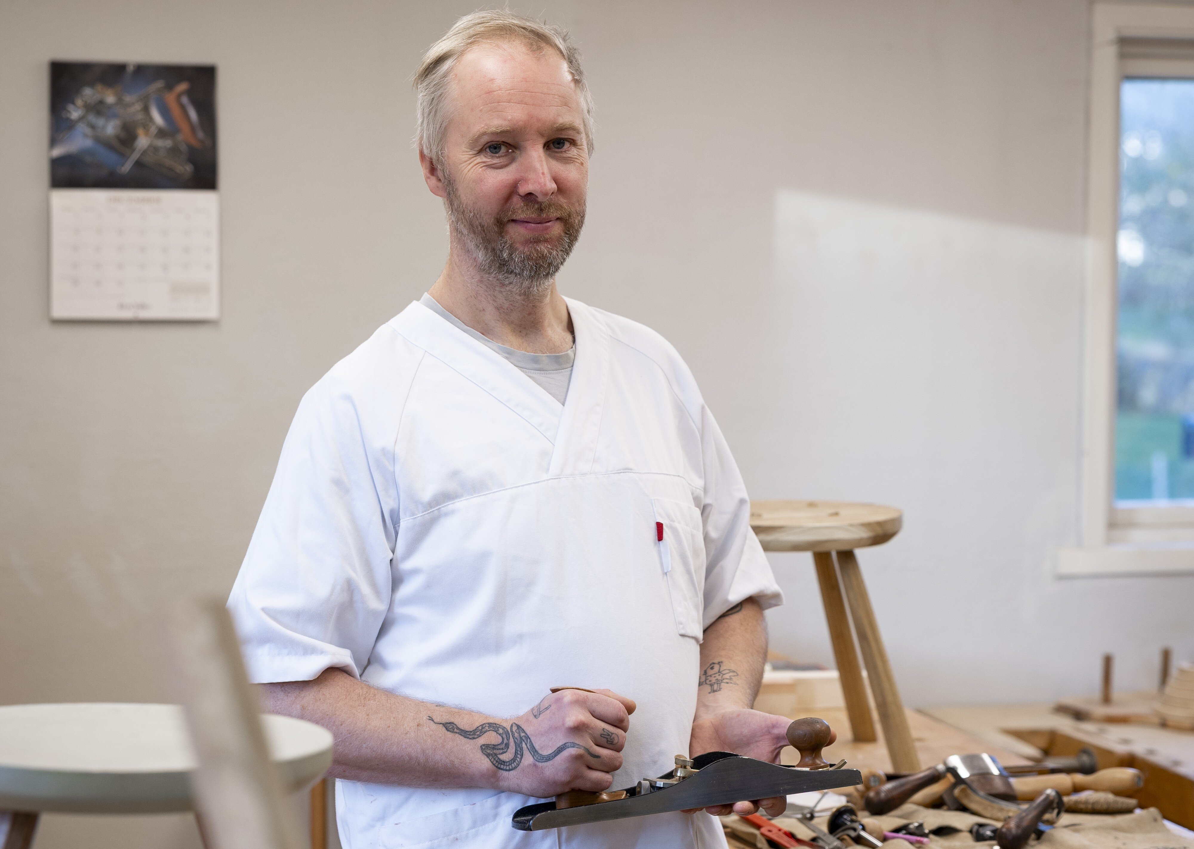Bildet viser Klaus Skrudland i sykepleieruniform på verkstedet.