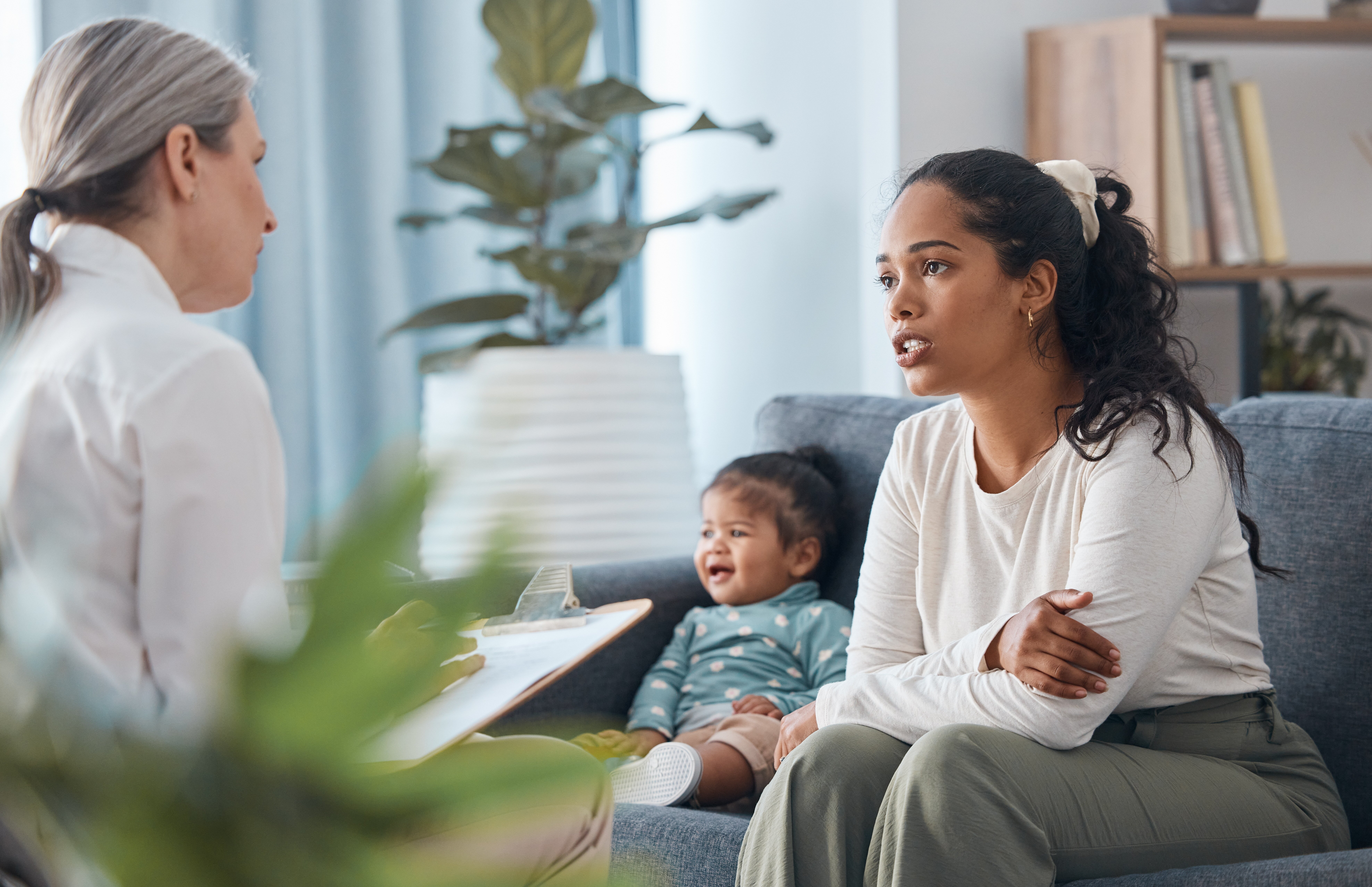 Bildet viser en mor og baby som sitter hos helsesykepleier