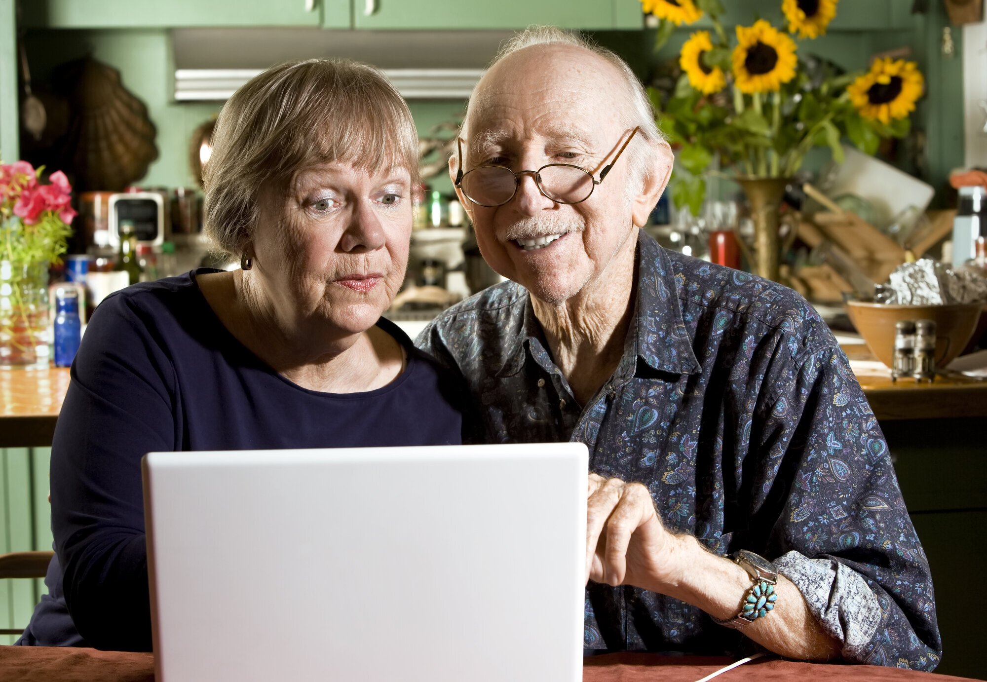 Eldre med pc Bildet viser to eldre personer som sitter foran en laptop