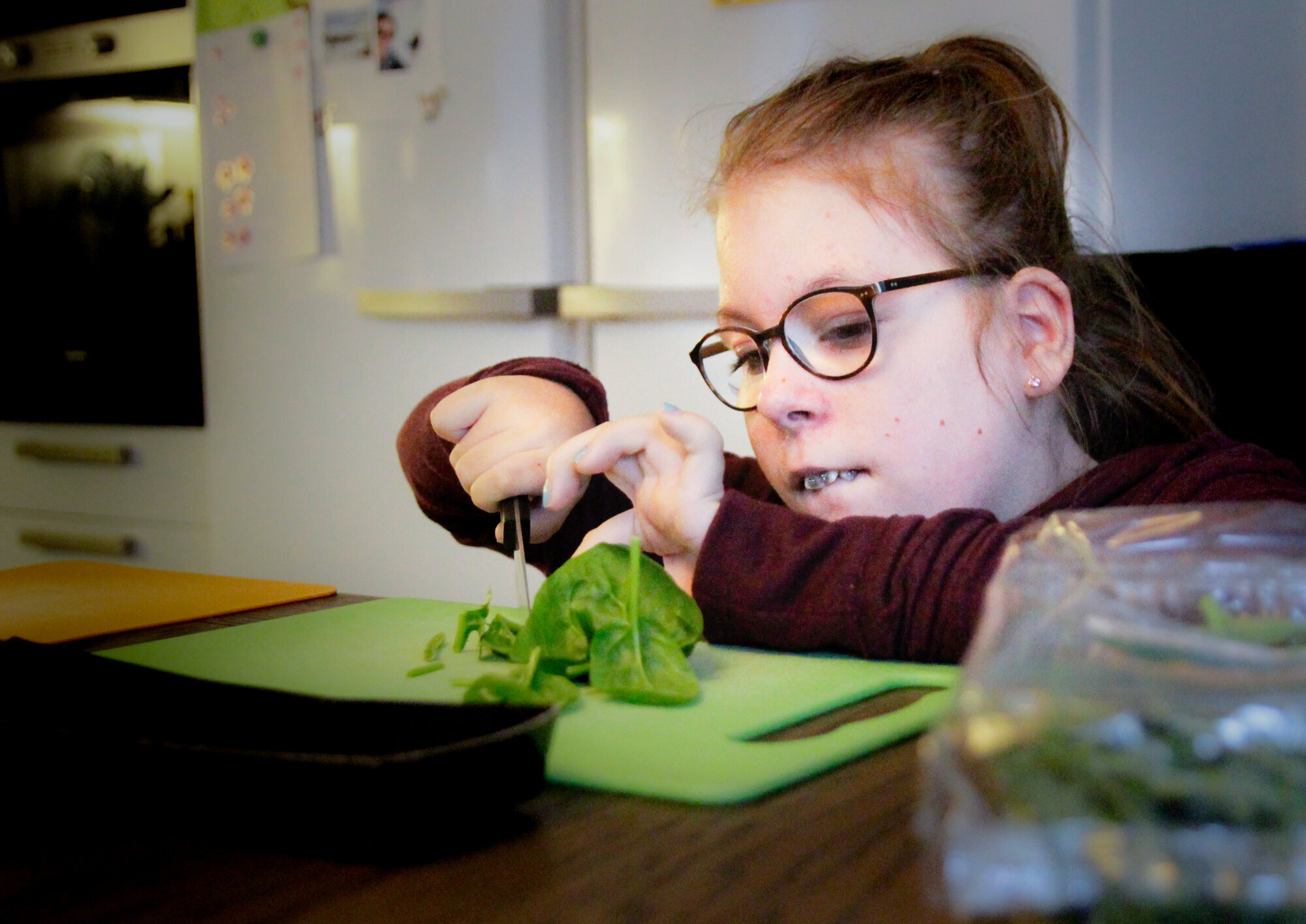 Emma skjærer salat Bildet viser at Emma skjærer salat