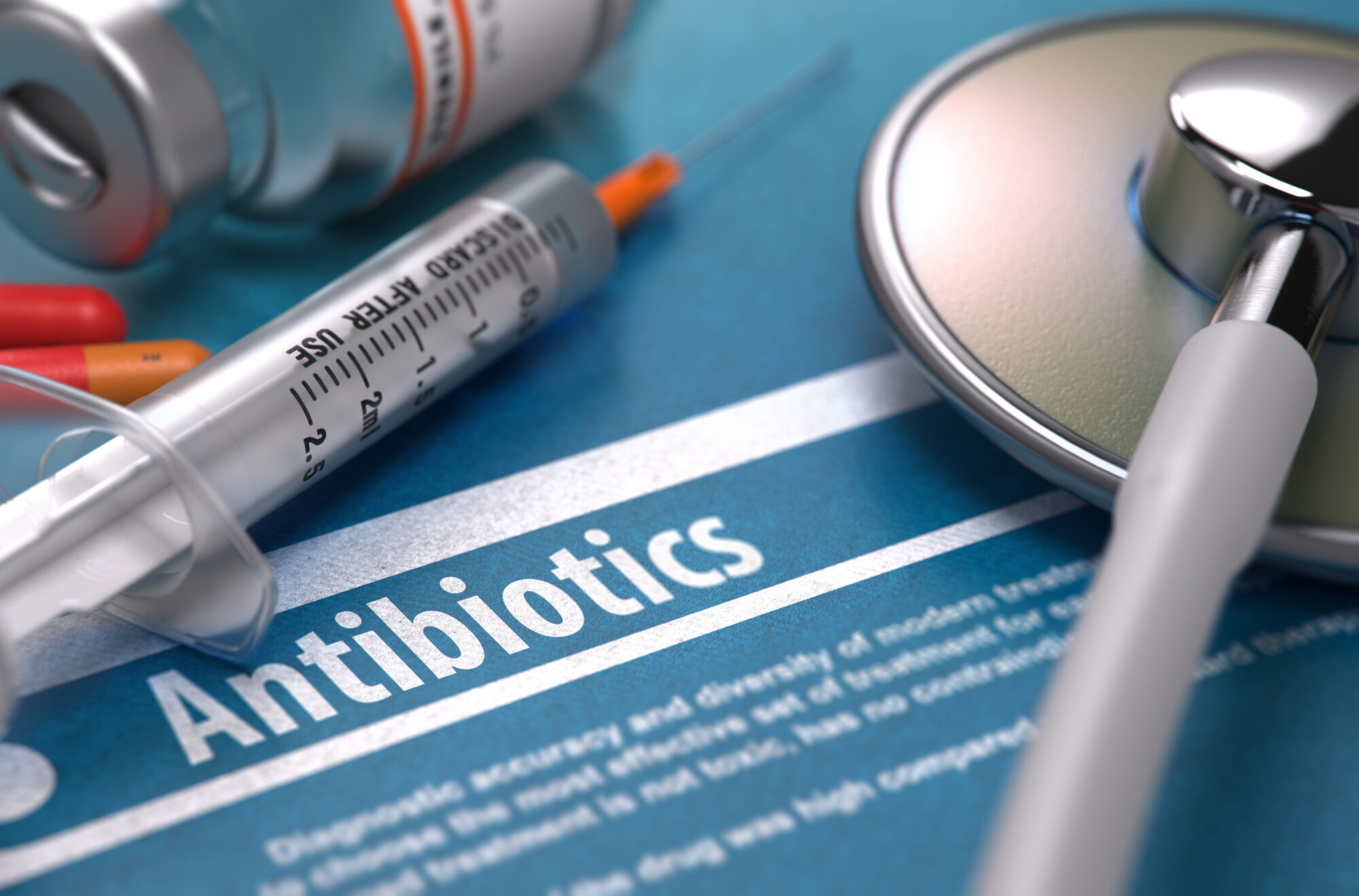 Bilde av sprøyte og antibiotika som ligger på en bakgrunn hvor det står "antibiotika" Bilde av sprøyte og antibiotika som ligger på en bakgrunn hvor det står "antibiotika"