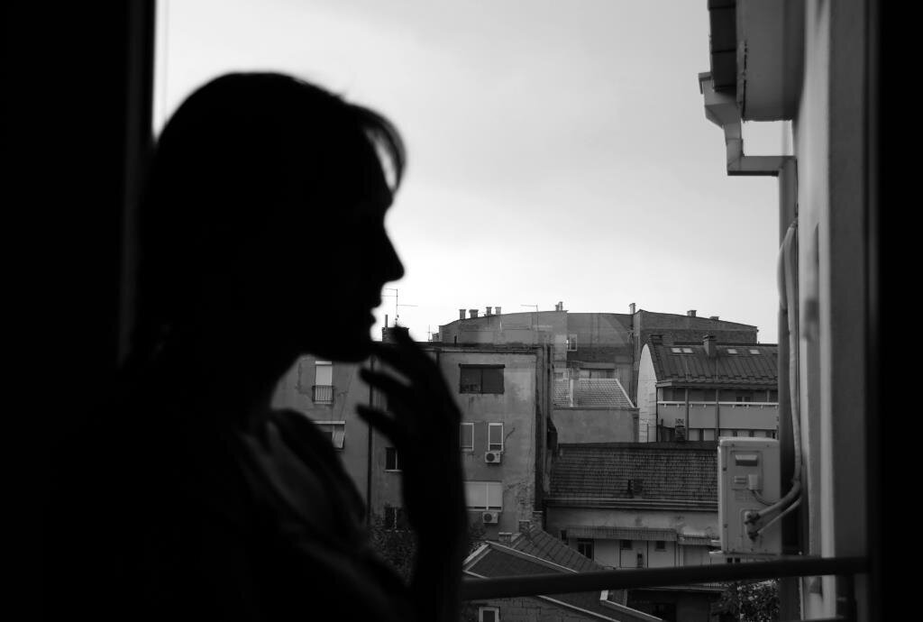 Langtidssykmeldte innvandrerkvinner forteller om isolasjon, uro og ensomhet, og mange er skeptiske til helsevesenets mulighet for å hjelpe. Bildet viser silhuetten av en kvinne ved et vindu med urban utsikt.