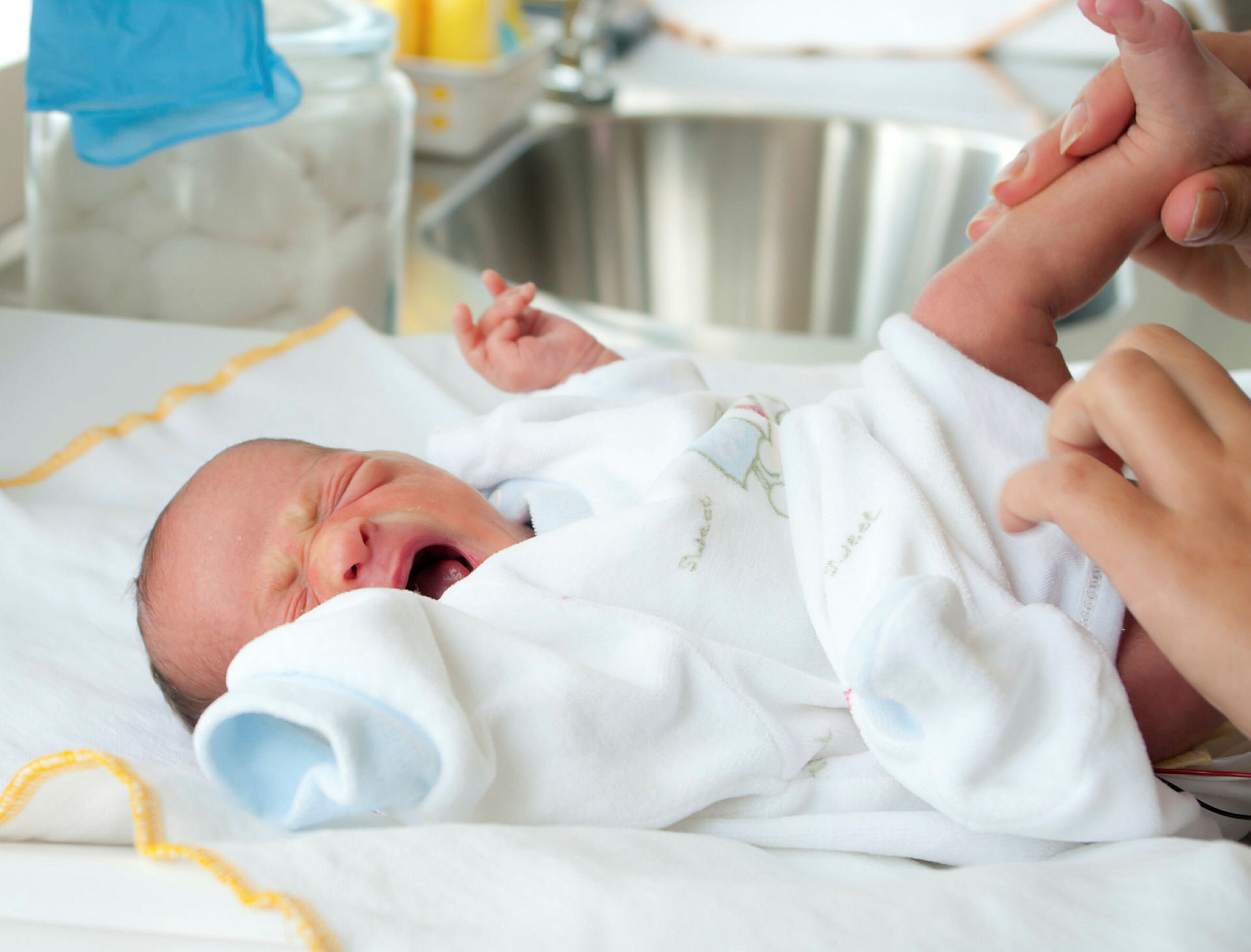 Bildet viser en baby som blir stelt og skriker.