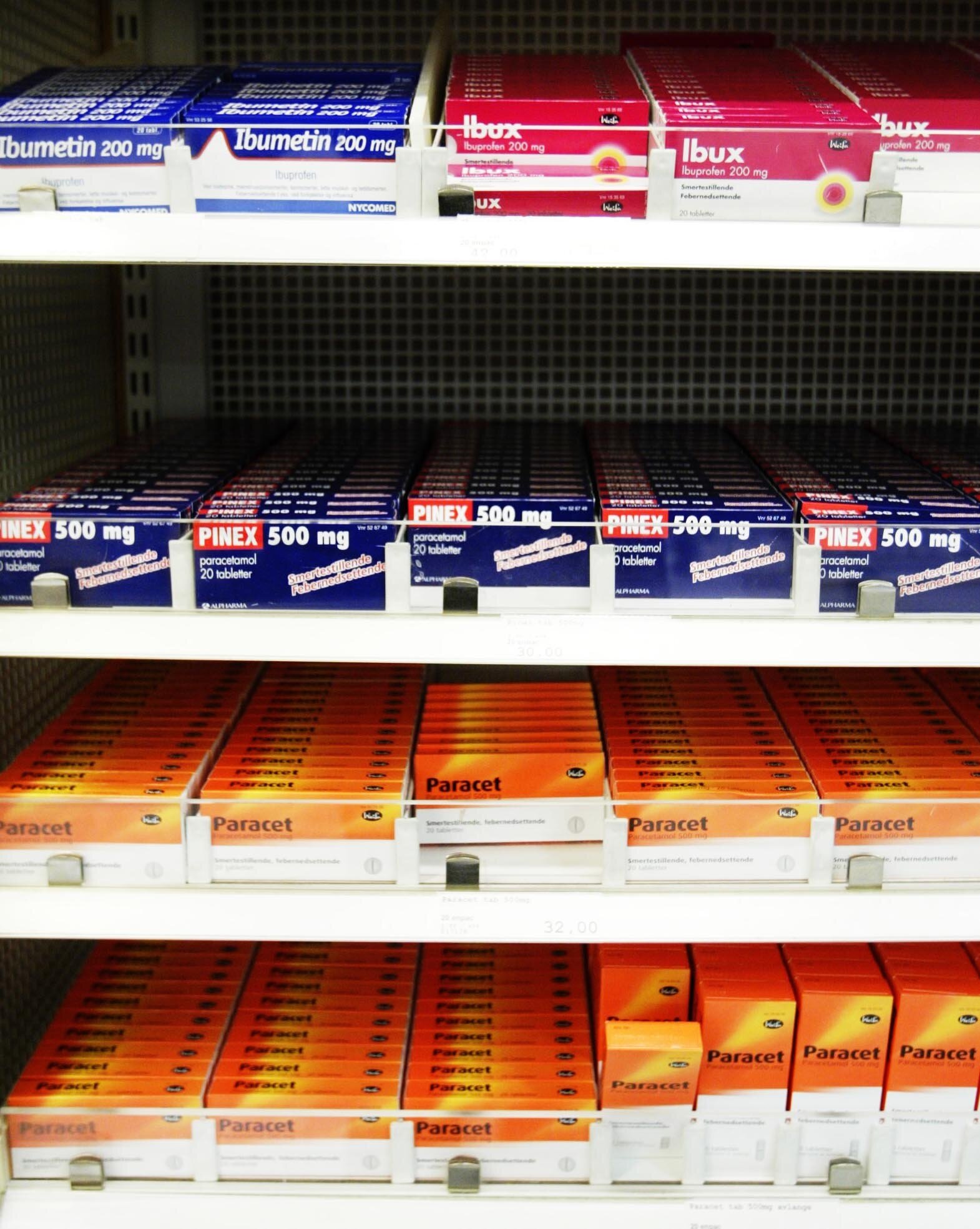 Smertestillende tabletter, paracetamol, ibuprofen Bildet viser pakninger med smertestillende tabletter, som Paracet og Ibux, i en hylle
