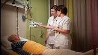 Veileder og sykepleierstudent Bildet viser en veileder og sykepleierstudent ved en pasient i senga