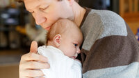 En far og en nyfødt baby Bildet viser en far og en nyfødt baby