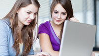 To studenter Bildet viser to kvinnelige studenter som ser inn i en pc-skjerm.