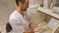 En mannlig sykepleier klargjør en sprøyte med antibiotika.