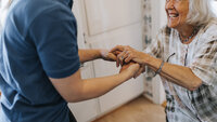 Bildet viser en sykepleier som geleider en pasient