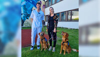 Bildet viser Susanne Rueness Espeseth og barnesykepleier Aleksander Hayes Sundby med terapihundene Aiva og Karma