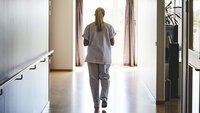 Bildet viser gående sykepleier bakfra