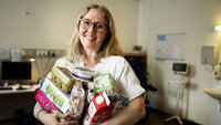 Bildet viser Ann Kristine Hammerstad som holder mange matvarer.