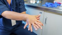 Bildet viser hendene til et helsepersonell som gjør håndhygiene.