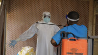 En helsearbeider blir desinfisert av en kollega inne på et behandlingssenter for ebolapasienter i Beni i Nord-Kivu-provinsen, øst i Kongo, tirsdag