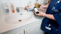 Urinstrimmeltest Bildet viser en hjemmesykepleier med en urinstrimmeltest på badet til brukeren