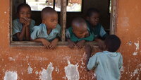Afrikanske barn som står og ser ut gjennom et åpent vindu Afrikanske barn som står og ser ut gjennom et åpent vindu