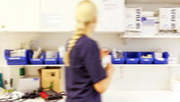 Sykepleier på vakt Bildet viser en sykepleier som finner frem medisiner på et medisinrom.
