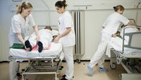 Sykepleiestudenter øver ved seng. Sykepleiestudenter som øver ved seng.