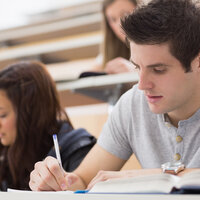 Studenter noterer under en forelesning.