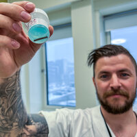 Bildet viser Lasse Johan Thue som holder et prøveglass.