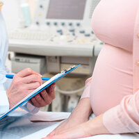 Bildet viser et utsnitt av en gravid kvinne hos legen